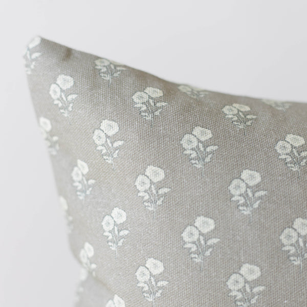 Beige linen pillow with repeating white floral botanical pattern throughout.
