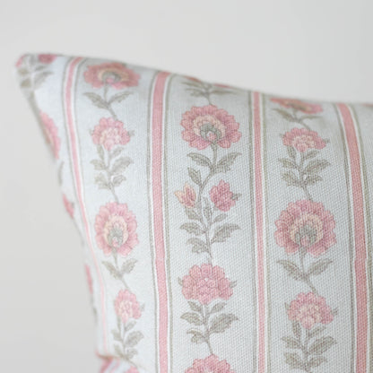 Decorative pillow with pink floral pattern and vertical stripes on cream background.