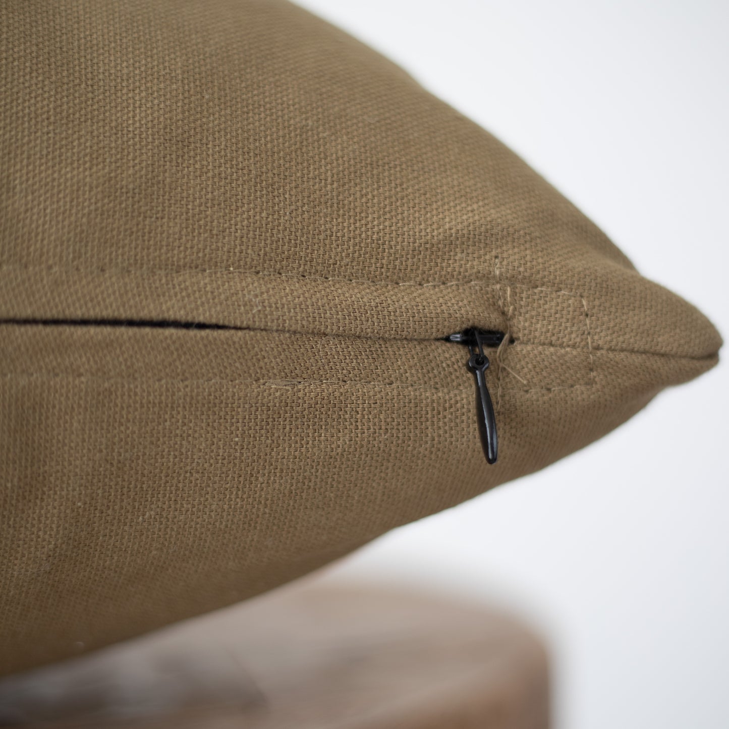 Taupe linen pillow cover with dark drawstring closure on side seam.