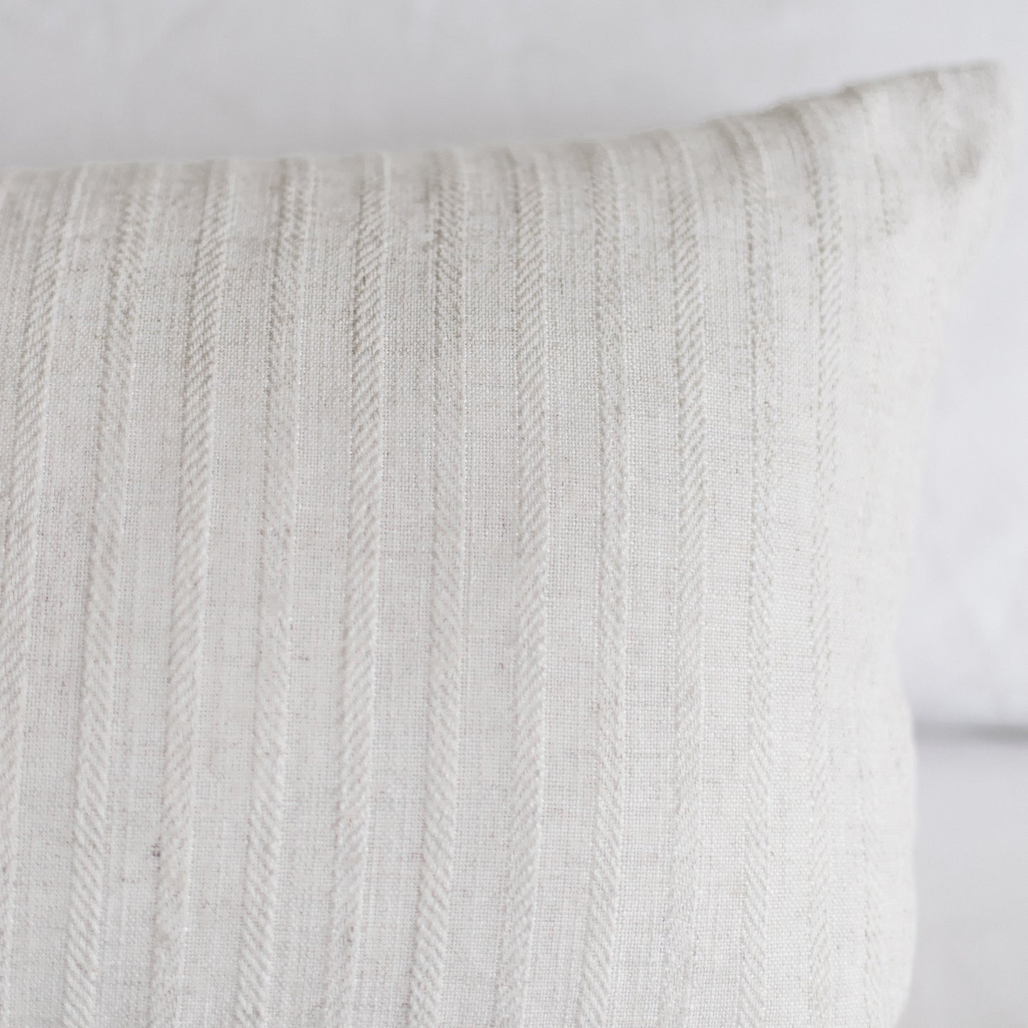 Cream-colored rectangular pillow with vertical cable knit texture pattern.