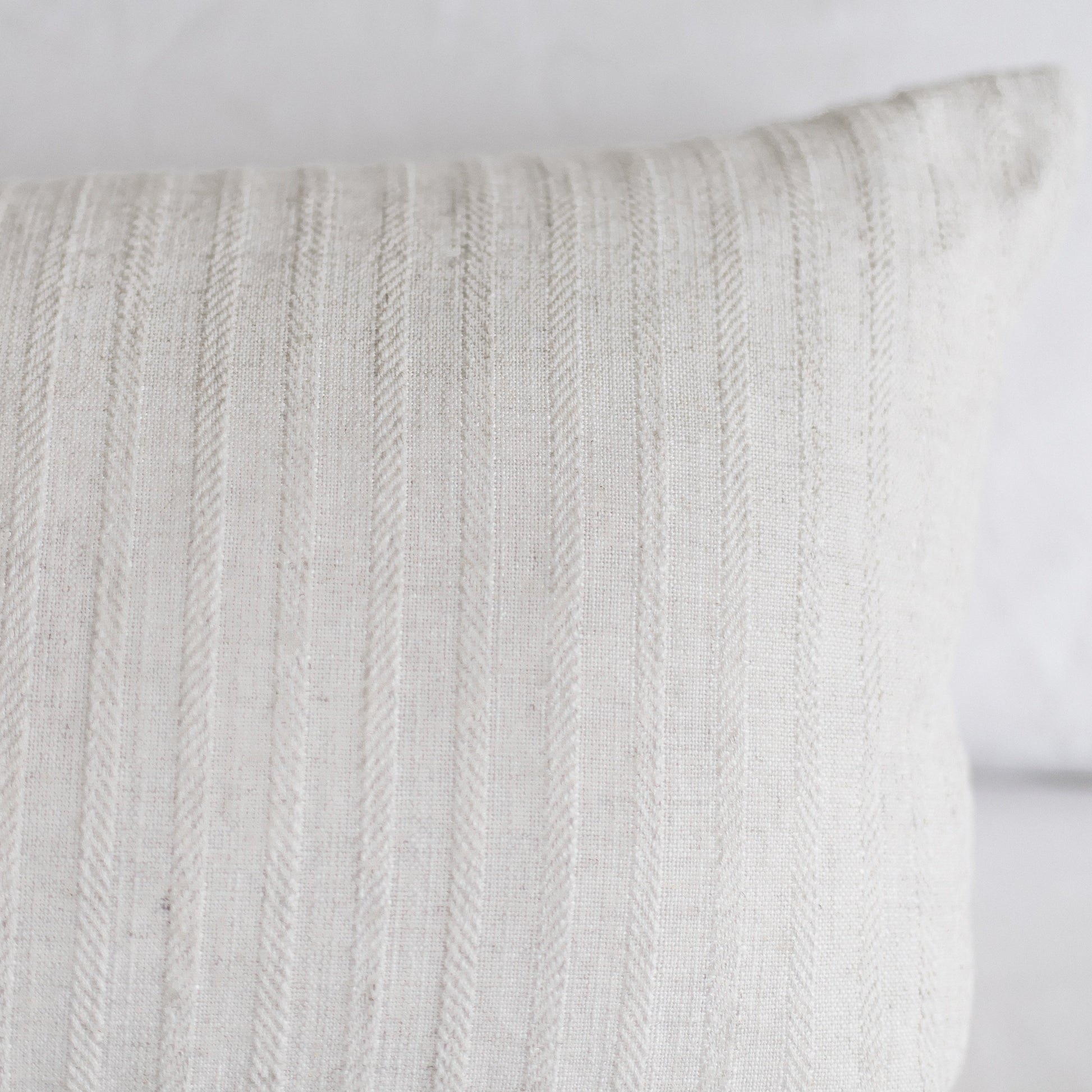 Cream-colored rectangular pillow with vertical cable knit texture pattern.