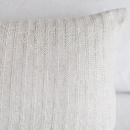 Cream-colored rectangular pillow with vertical cable knit texture pattern.