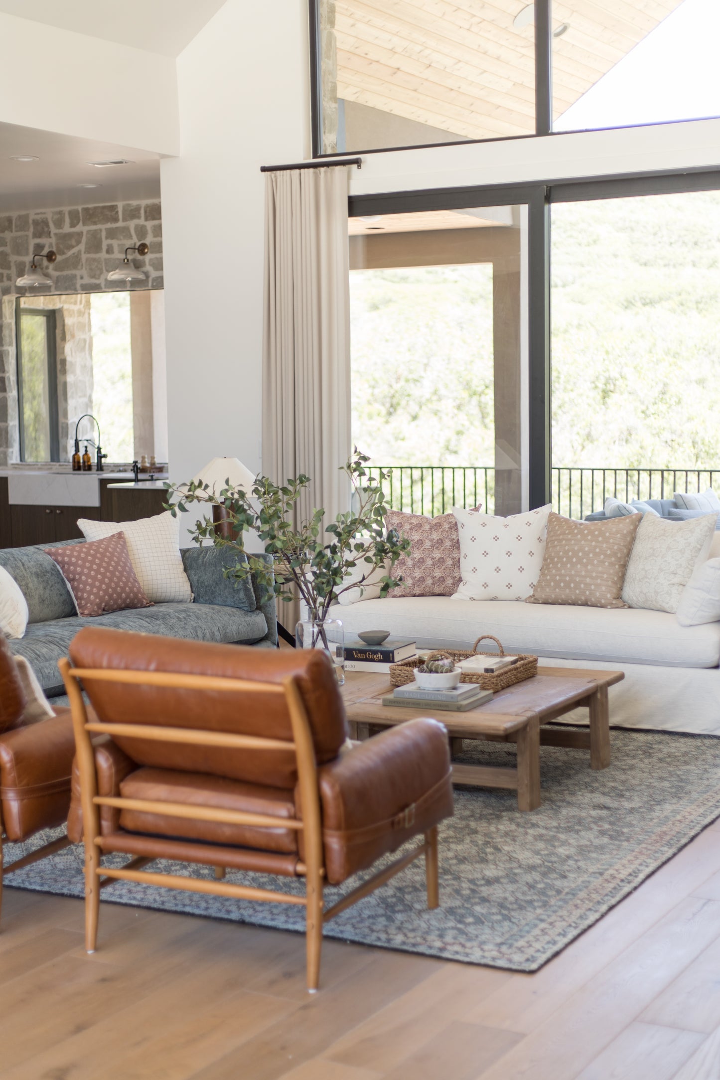 Four decorative pillows in varied patterns including mauve, cream, and neutral tones arranged on a light gray sofa.