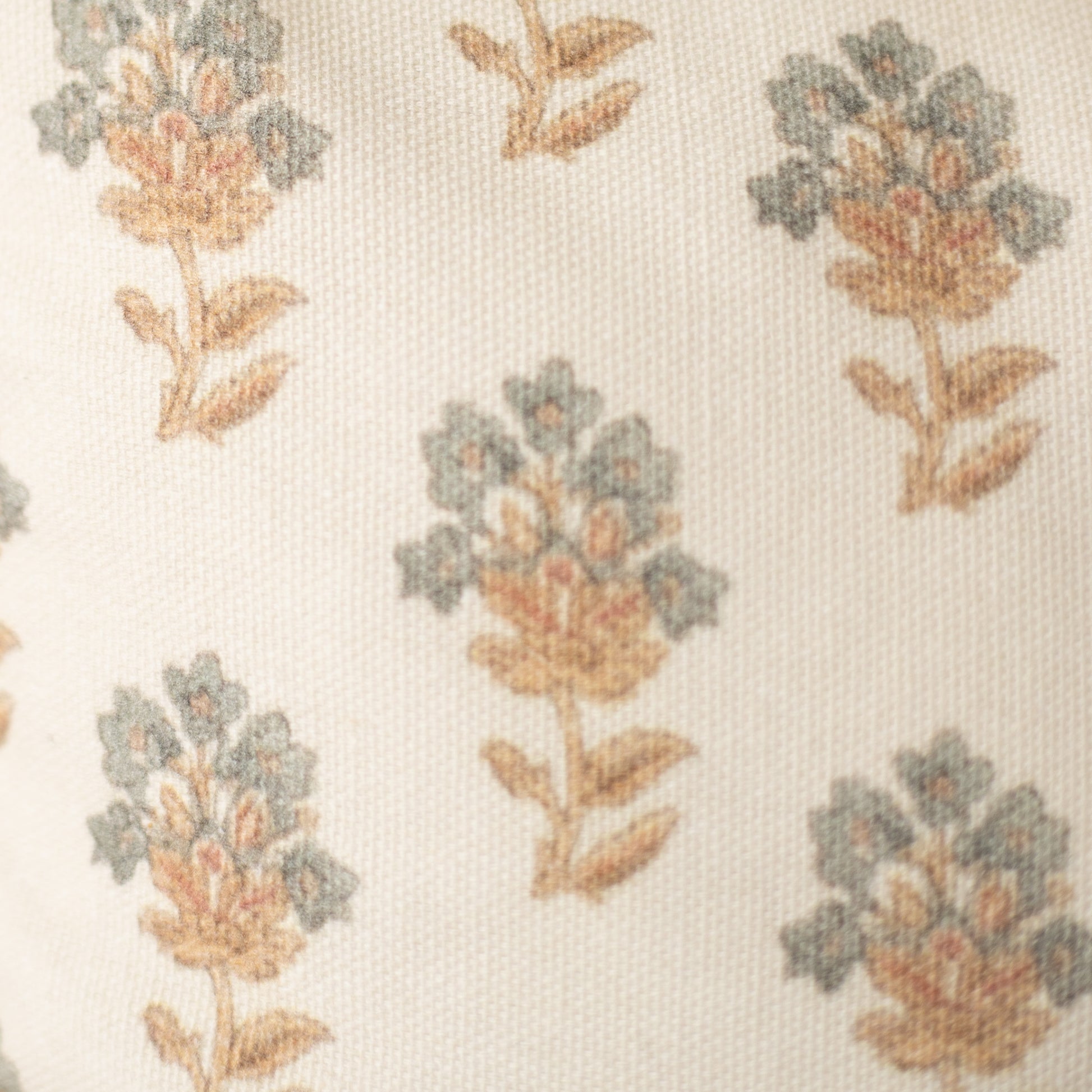 Cream fabric with repeating botanical pattern of flowers in sage green, coral, and tan with brown stems and leaves.