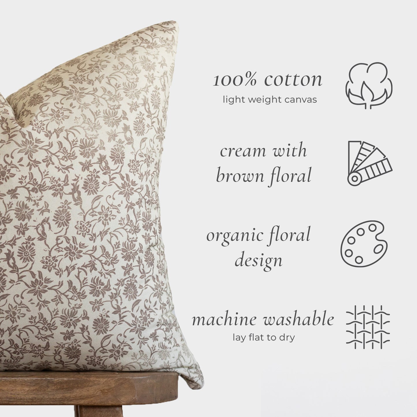 Cream cotton pillow with brown floral pattern, displayed on wooden base with care icons.