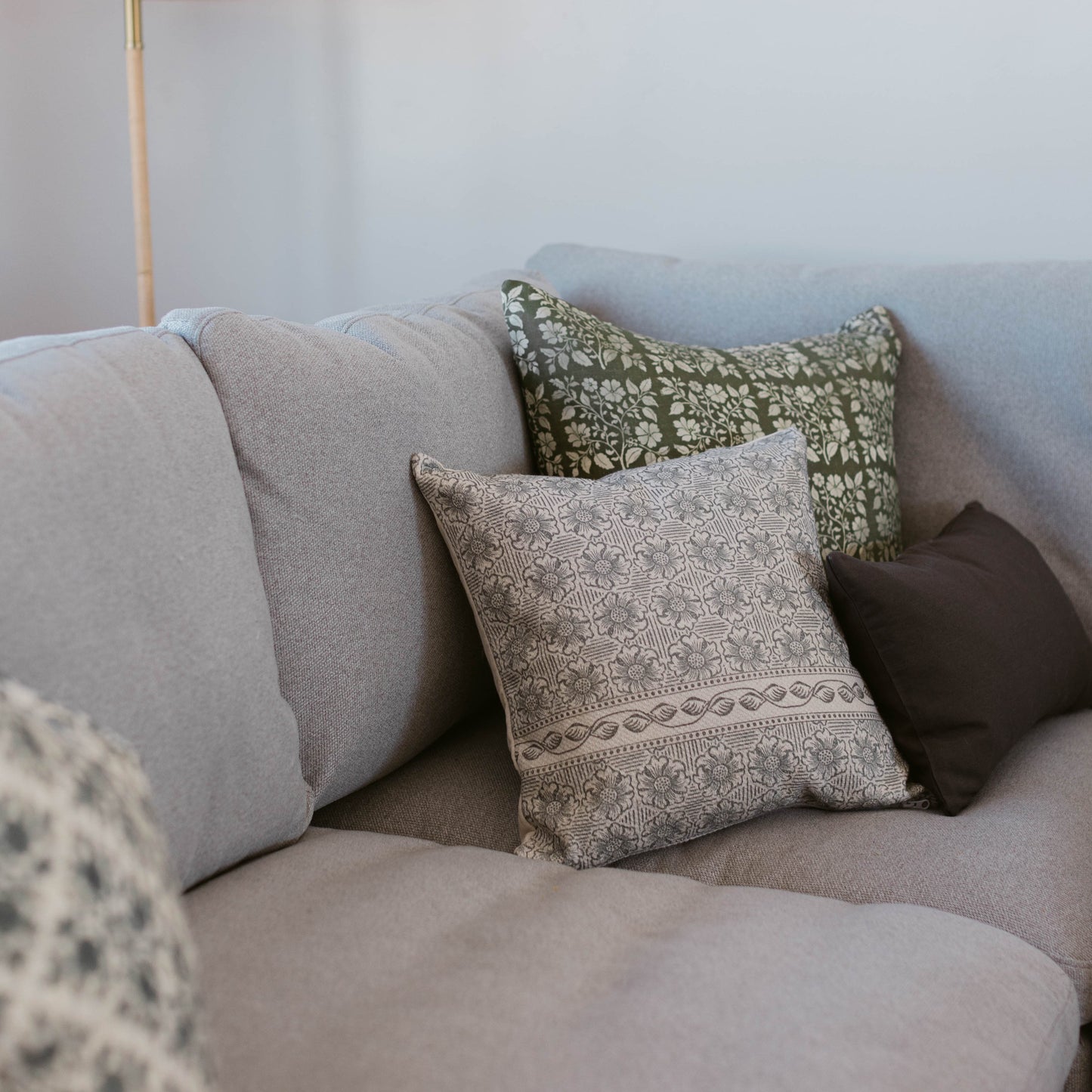 Light gray thick weave pillow displayed on a sofa with patterned accent pillows.