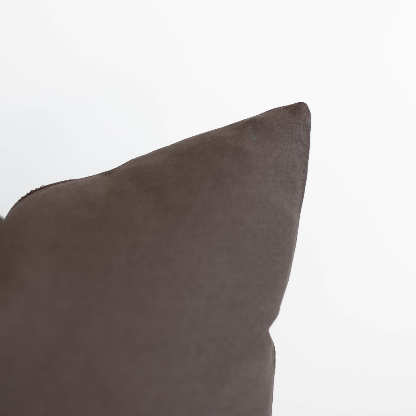 Charcoal gray double-sided pillow cover with textured fabric and piped edge detail.
