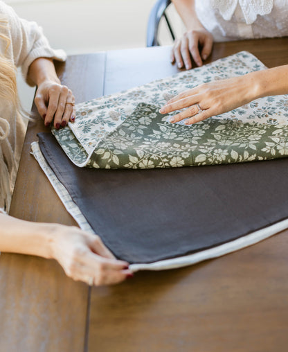 Linen pillow with green and white floral pattern, shown folded to display front design and gray backing.