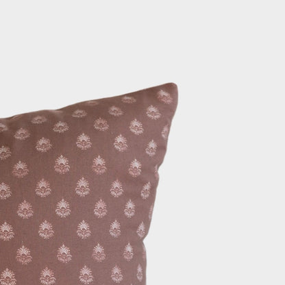 Clay-colored pillow with repeating cream damask pattern throughout.