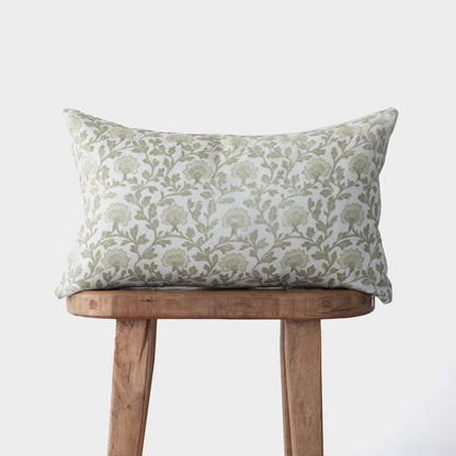 Rectangular linen pillow with sage green floral botanical print, displayed on wooden stool.