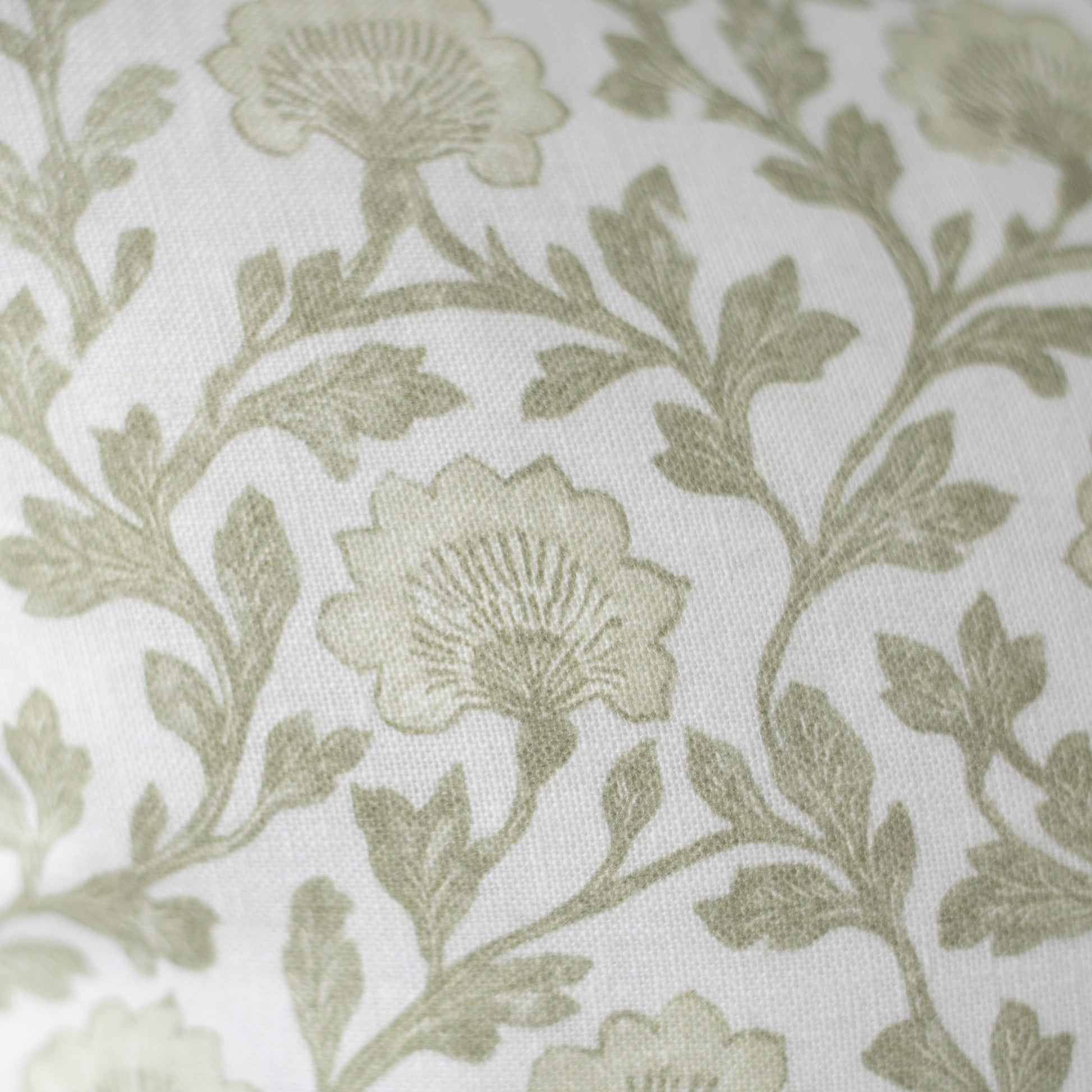 Sage green floral and leaf pattern on cream linen fabric with textured weave.