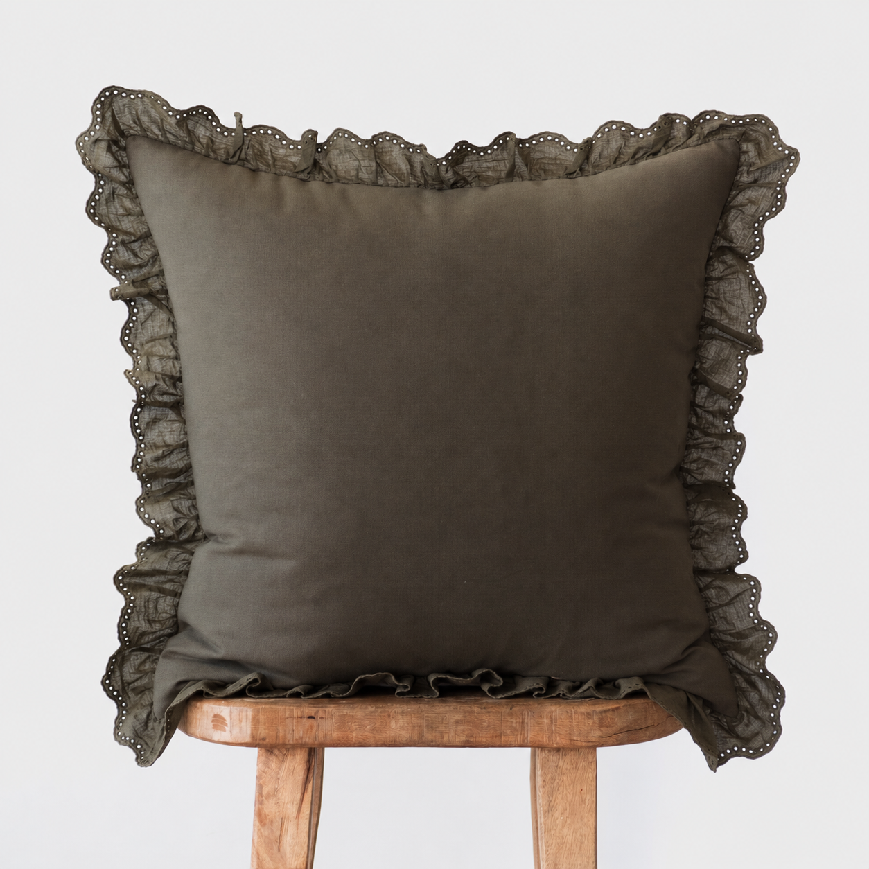 Dark olive square pillow with ruffled eyelet lace trim on all sides.