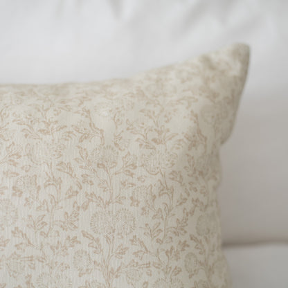 Cream decorative pillow with subtle damask pattern and floral texture throughout.
