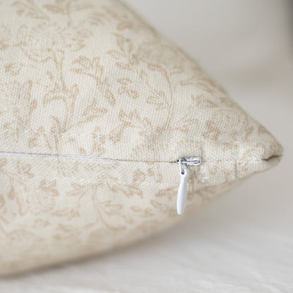 Beige decorative pillow with damask pattern and white zipper closure.