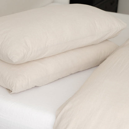 Beige duvet cover set with two pillows arranged on a bed, showing subtle textured fabric.