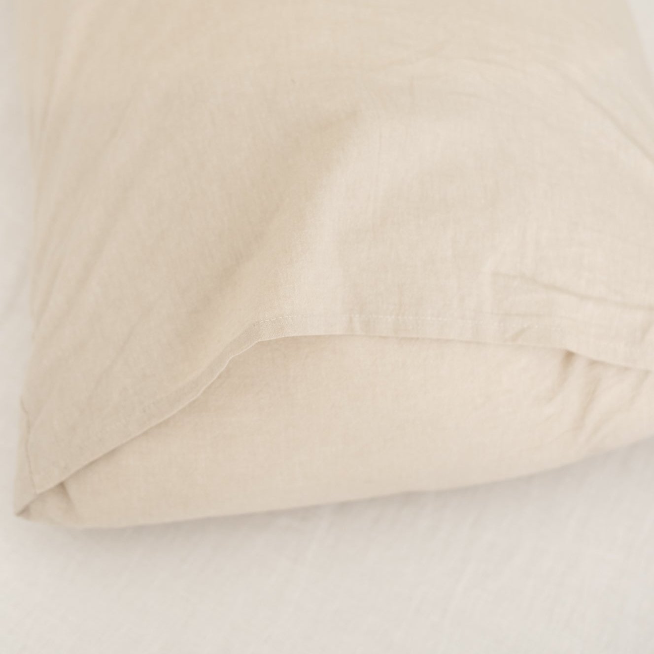 Beige duvet cover folded and layered, showing smooth fabric texture and neutral color.