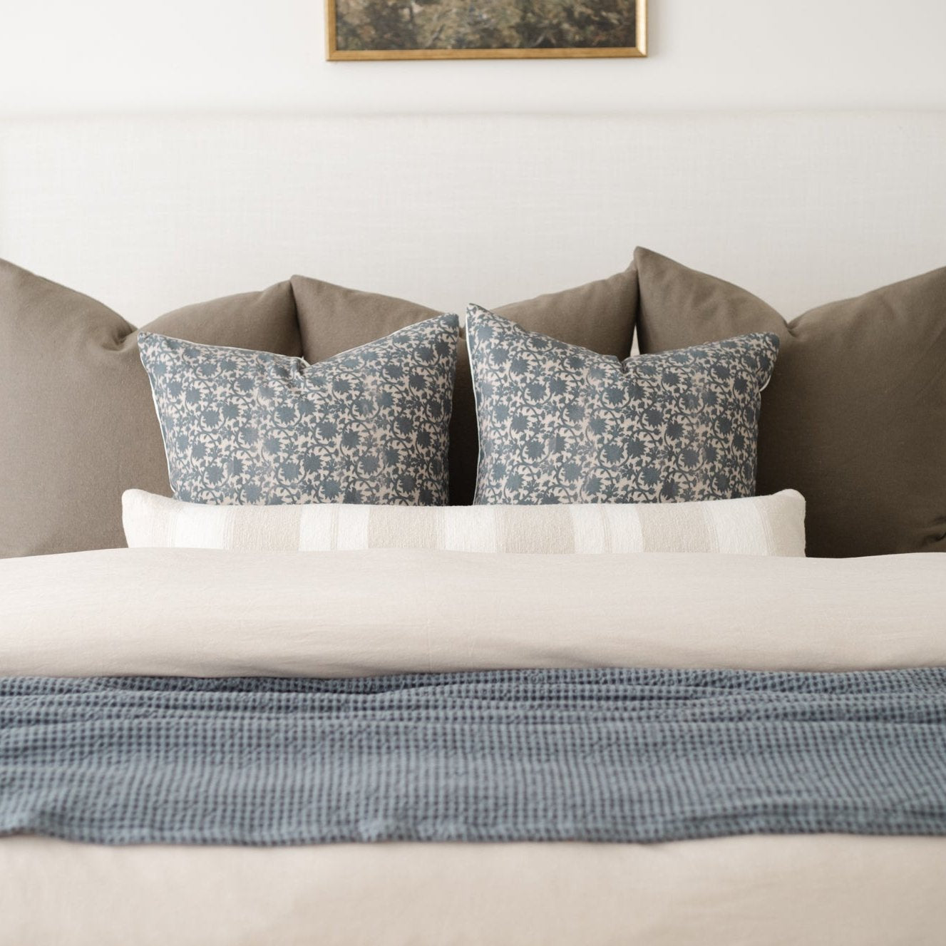 Beige duvet cover styled on a bed with matching pillows and decorative throw pillows.