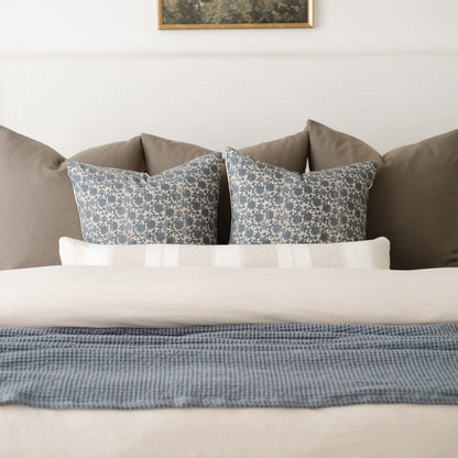 Beige duvet cover styled on a bed with matching pillows and decorative throw pillows.