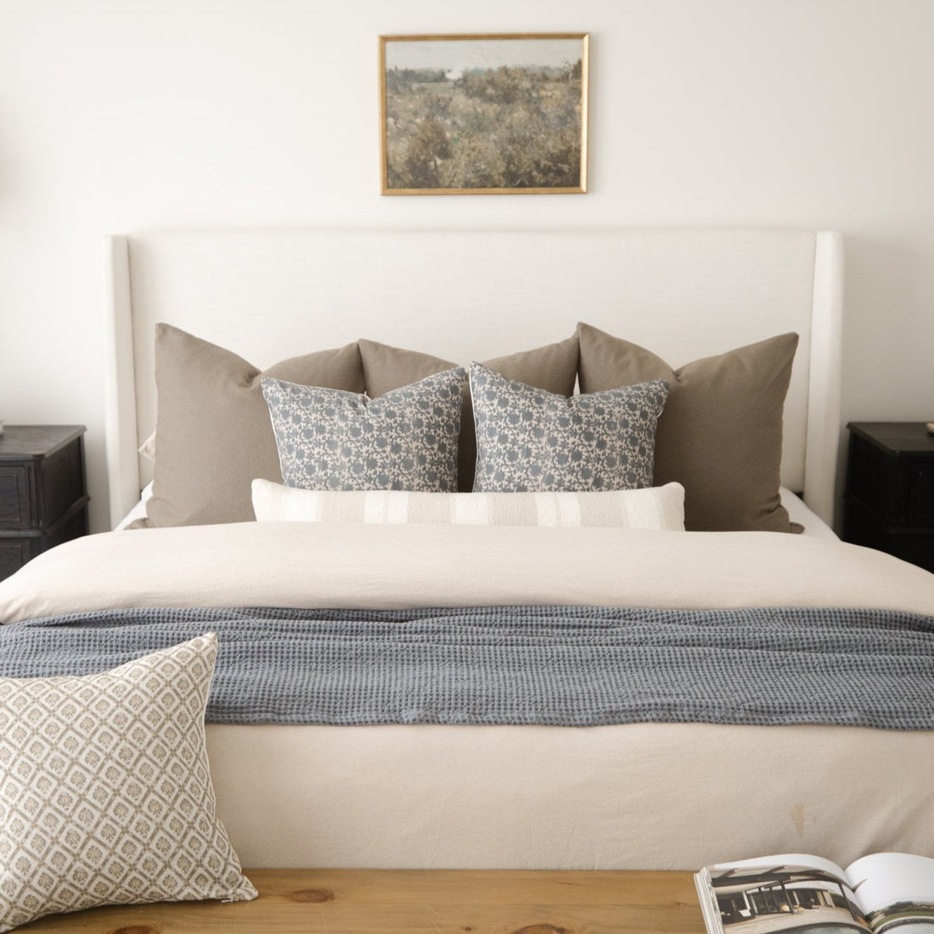 Beige duvet cover on bed with matching pillows and decorative patterned cushions.
