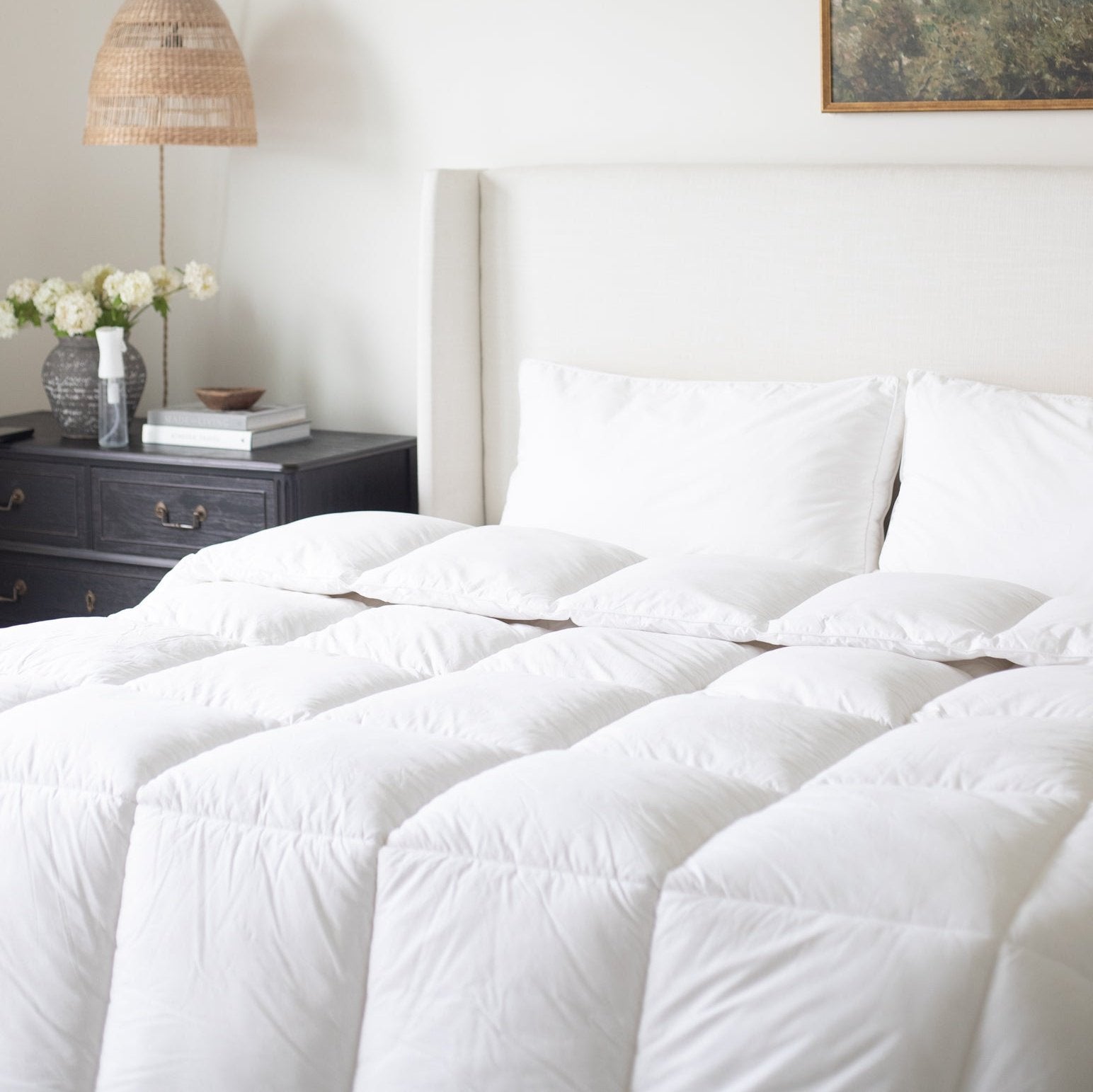 White quilted duvet insert with diagonal stitching pattern displayed on bed with pillows.