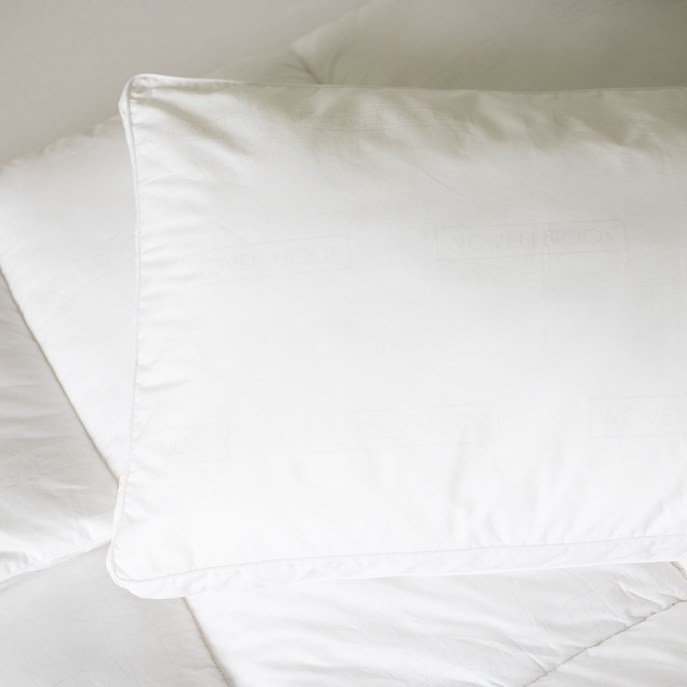 White king-size sham pillow with faux down fill displayed on a bed.