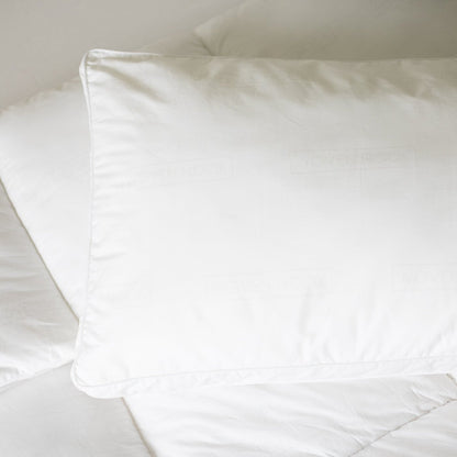 White king-size sham pillow with faux down fill displayed on a bed.