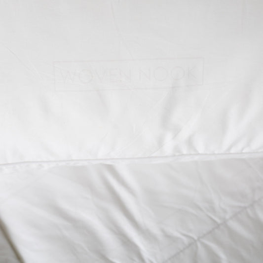 White rectangular pillow sham with quilted texture and stitched seams.