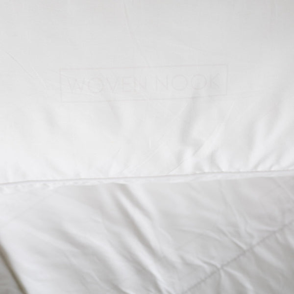 White rectangular pillow sham with quilted texture and stitched seams.