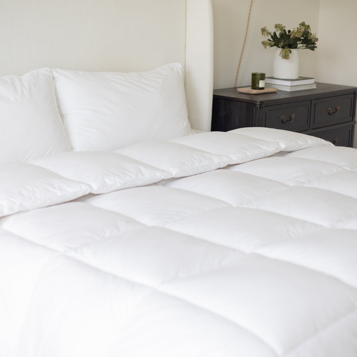 White quilted duvet insert on king-size bed with two matching pillows.