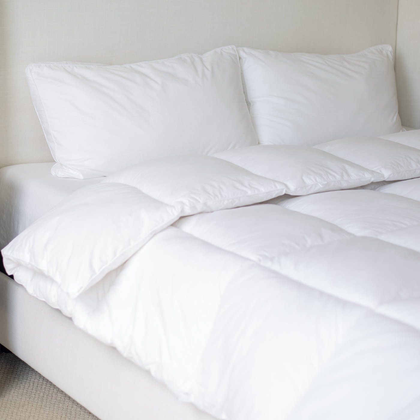 White quilted king duvet insert displayed on a bed with two pillows.