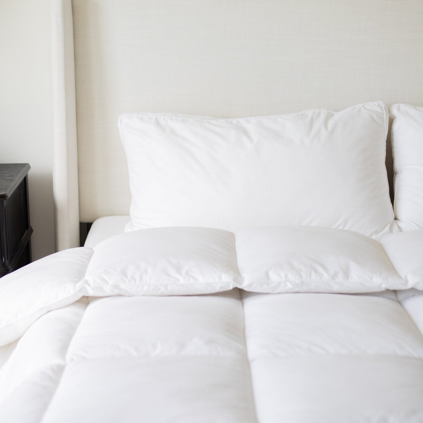 White king duvet insert displayed on a bed with two pillows against a beige wall.