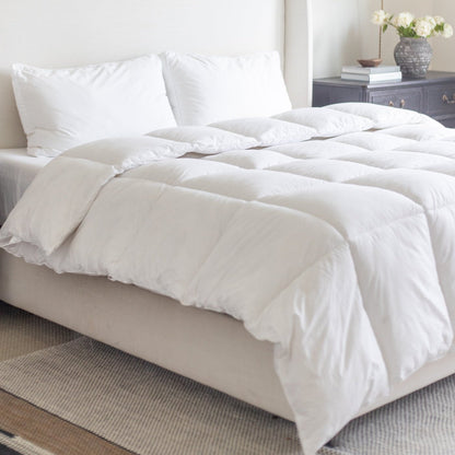 White quilted king duvet insert on bed with two pillows and headboard.