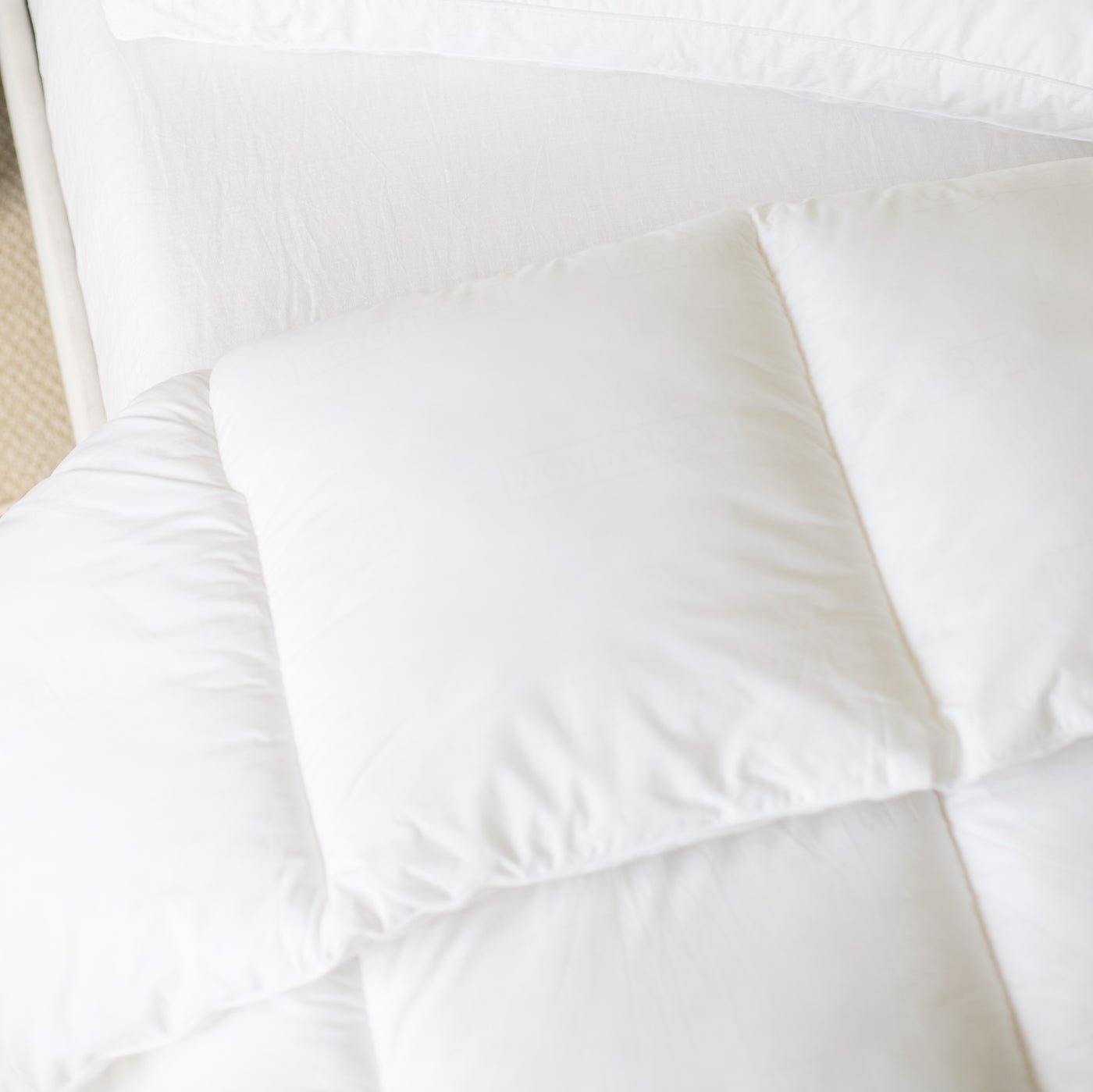 White quilted king duvet insert with internal baffle box construction, displayed flat on a bed.