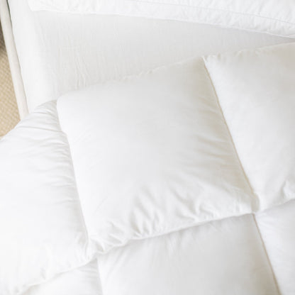 White quilted king duvet insert with internal baffle box construction, displayed flat on a bed.