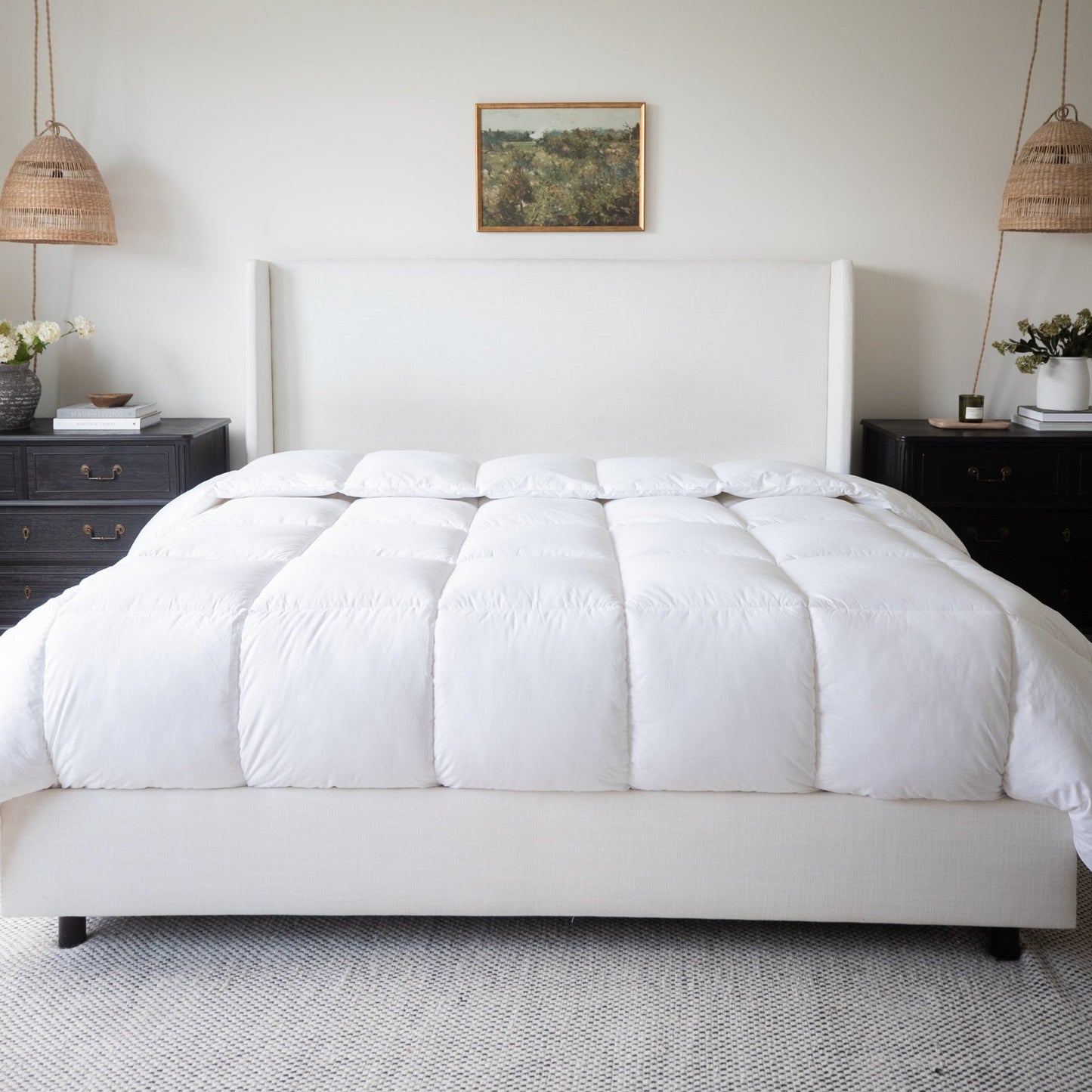 White quilted king duvet insert with box-stitched pattern on bed with upholstered headboard.