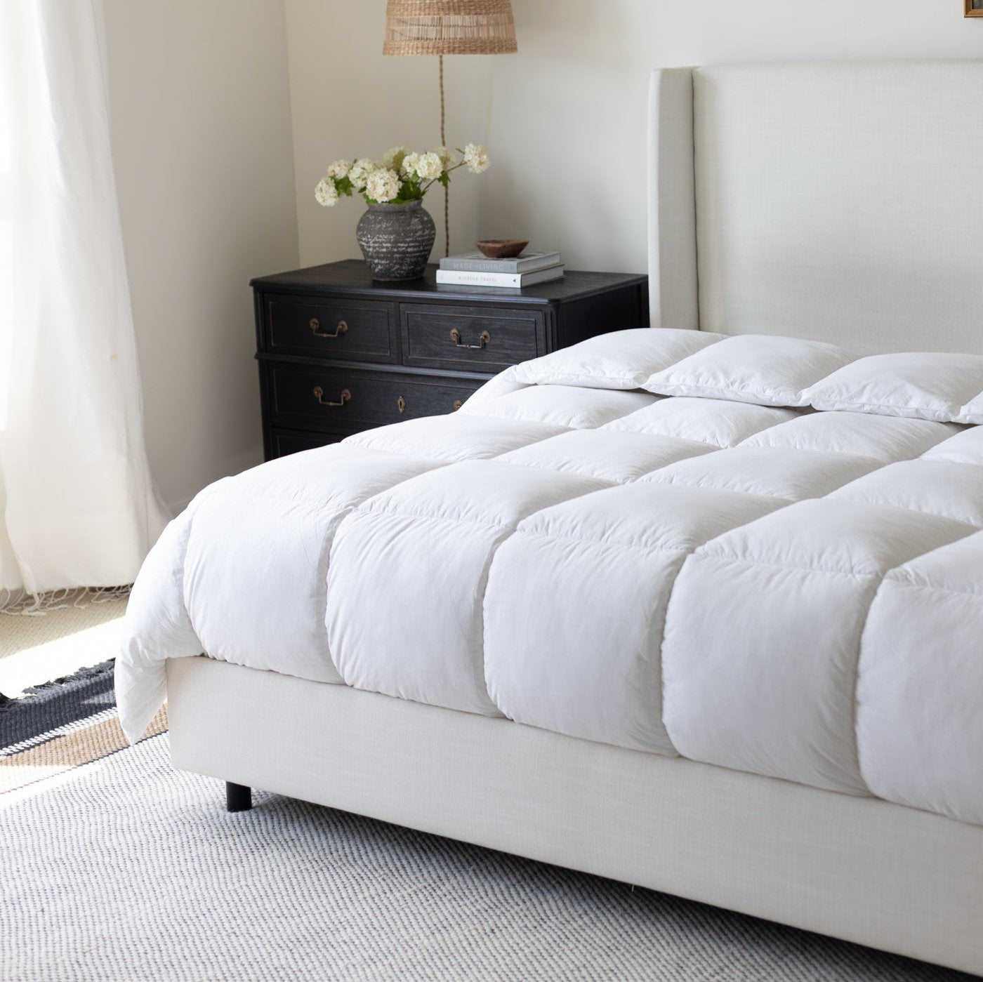 White quilted king duvet insert on bed with two pillows, displayed in bedroom setting.