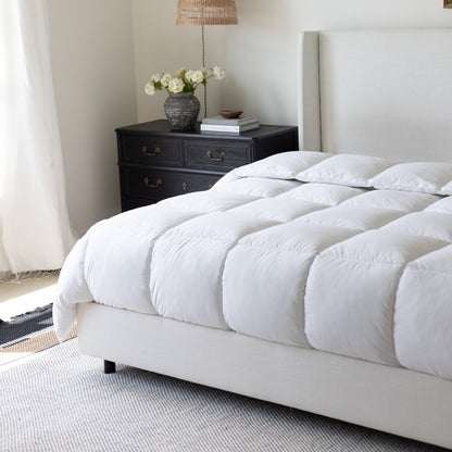White quilted king duvet insert on bed with two pillows, displayed in bedroom setting.