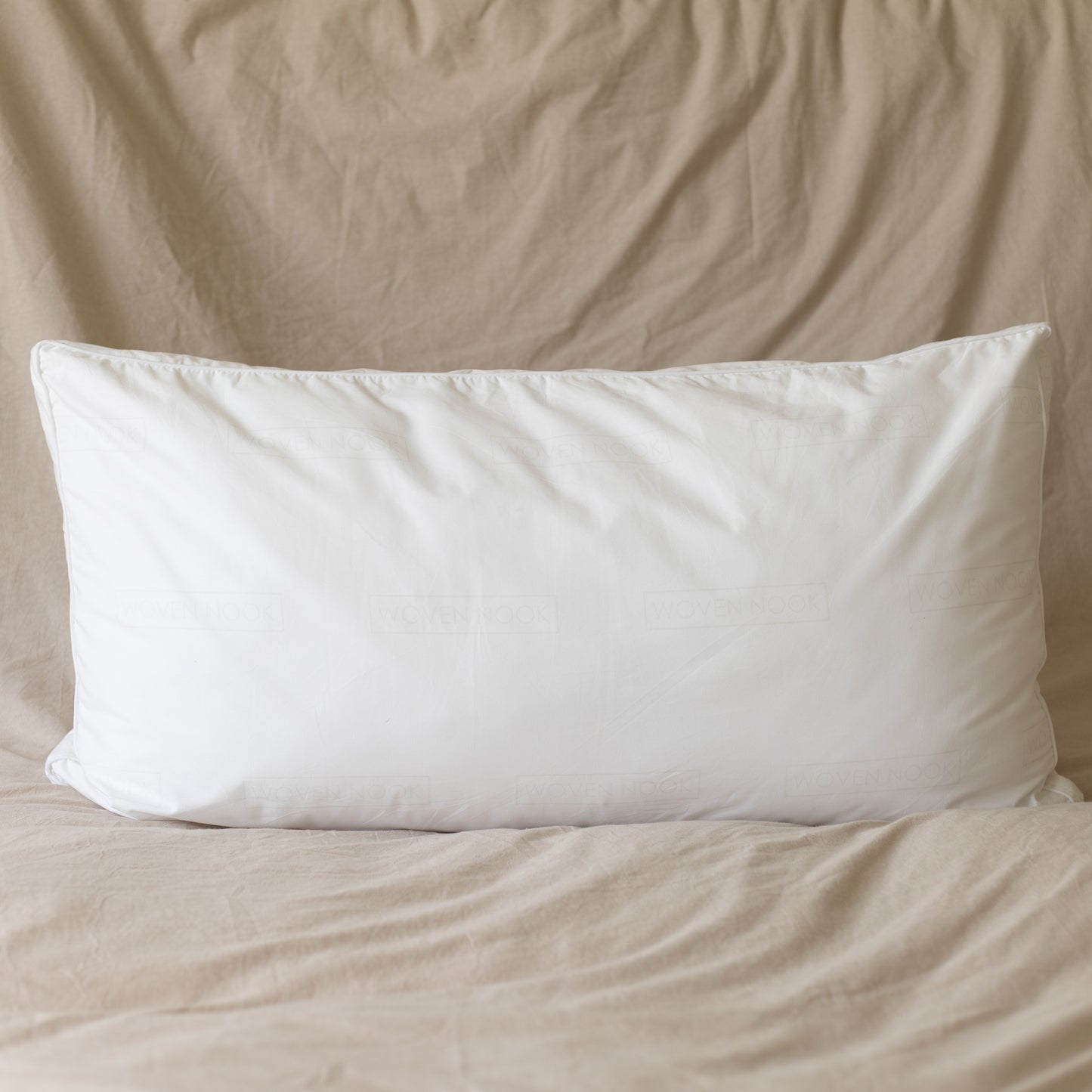 White rectangular pillow insert with faux down fill, king sham size, displayed on beige bedding.