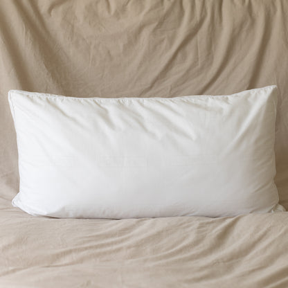 White rectangular pillow insert with faux down fill, king sham size, displayed on beige bedding.