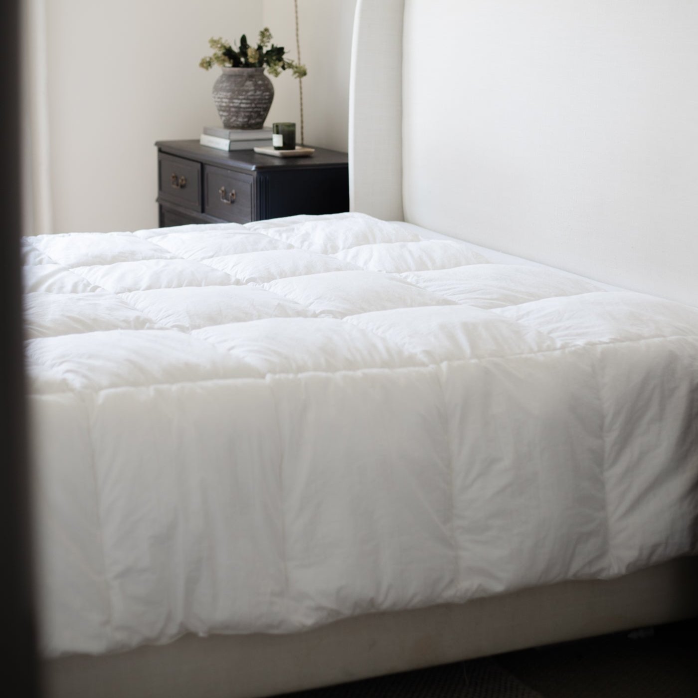 White quilted duvet insert with box stitching pattern displayed on a bed.