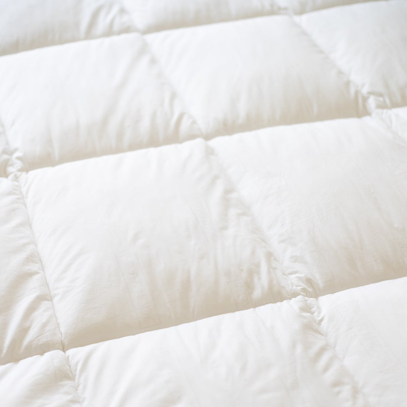White quilted duvet insert with baffle-box stitching pattern and filled compartments.