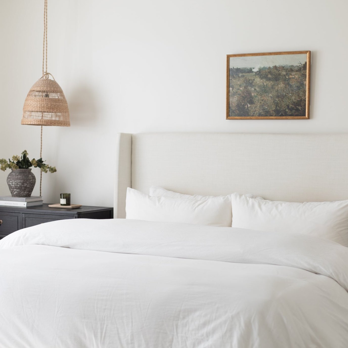 White duvet cover and pillowcases on a king bed with matching white pillows.
