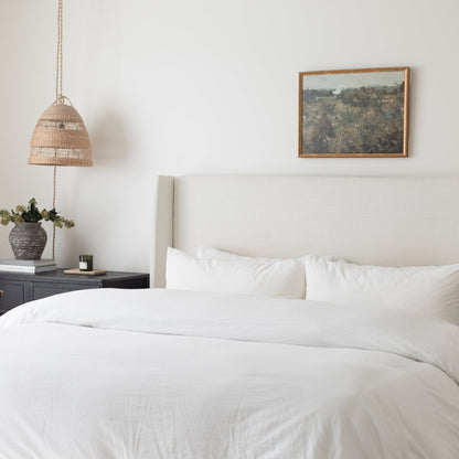 White duvet cover and pillowcases on a king bed with matching white pillows.