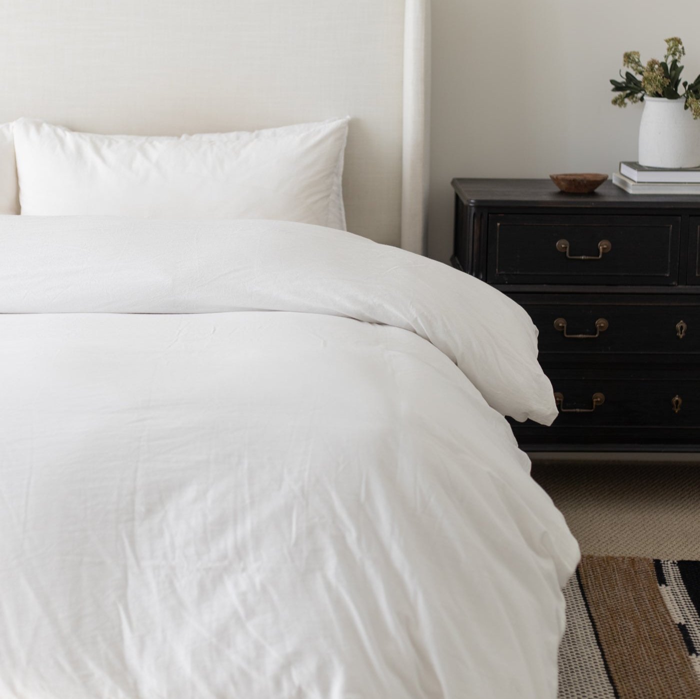 White king duvet cover set on bed with matching pillowcase and black nightstand.