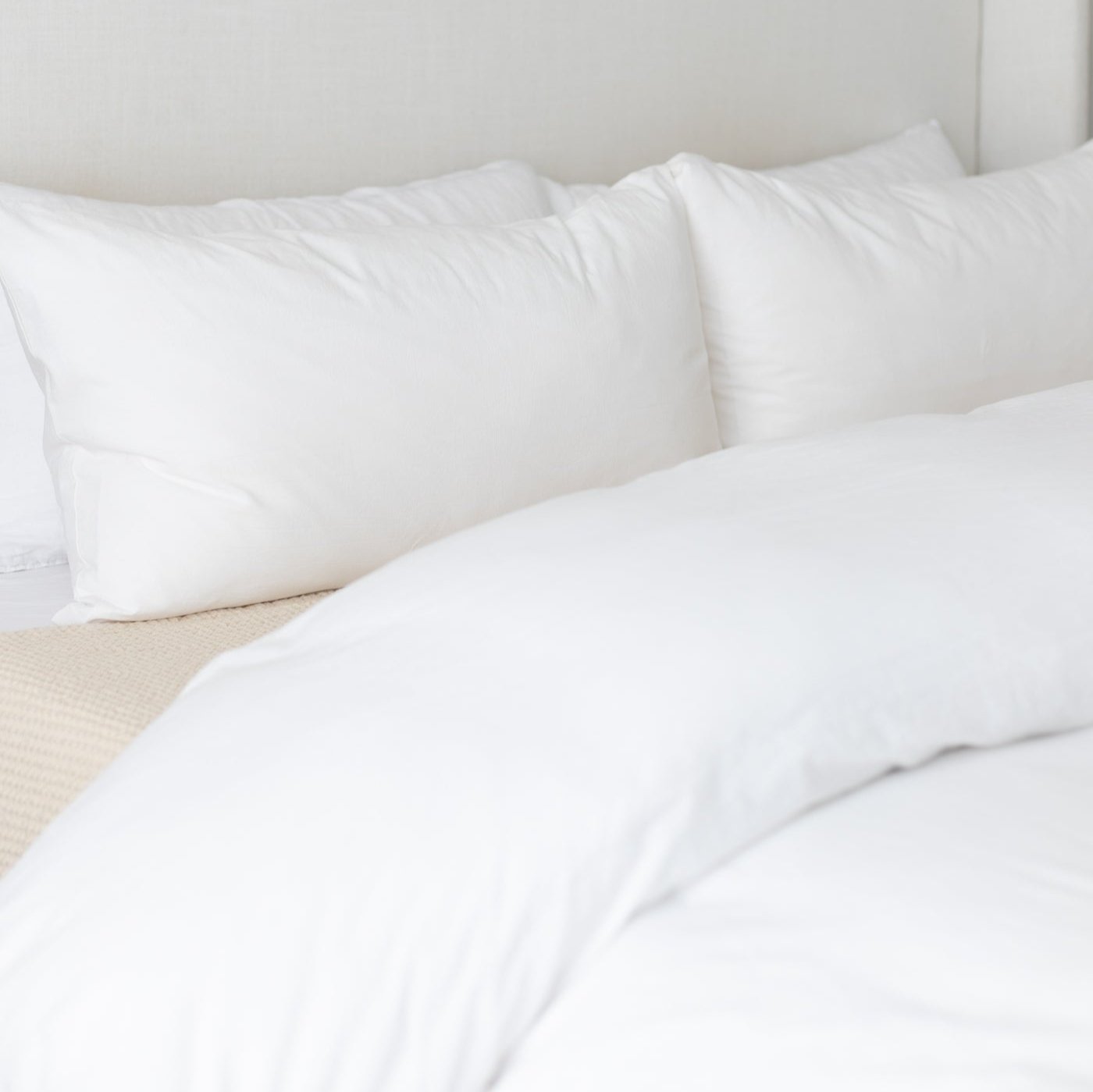 White king duvet cover set with matching pillowcases arranged on a bed with gray headboard.