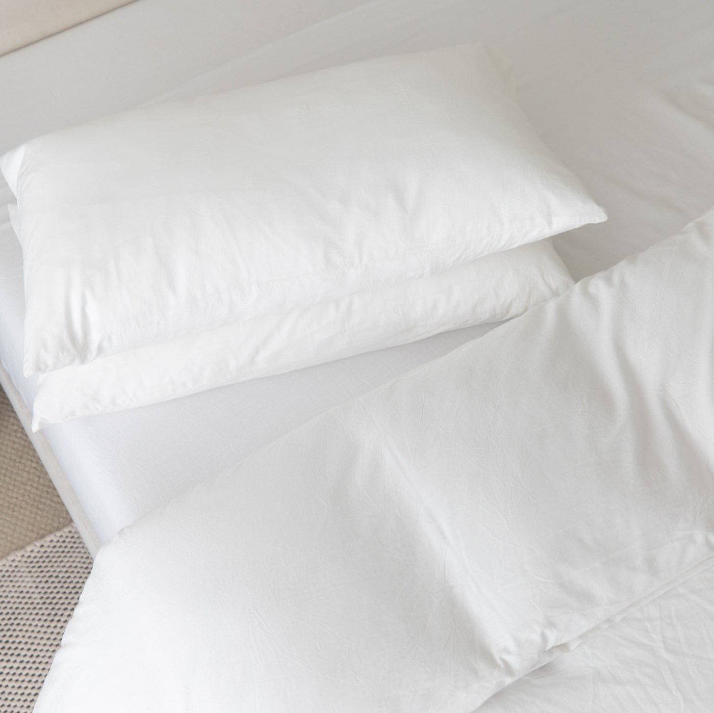 White duvet cover set with two matching pillowcases arranged on a bed.