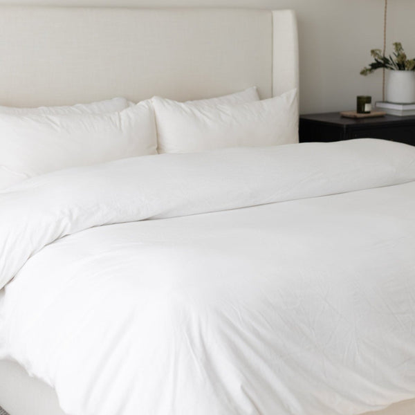 White king duvet cover and insert set on bed with matching pillows and upholstered headboard.
