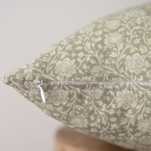 Beige and cream damask patterned pillow with white zipper closure detail visible on side.