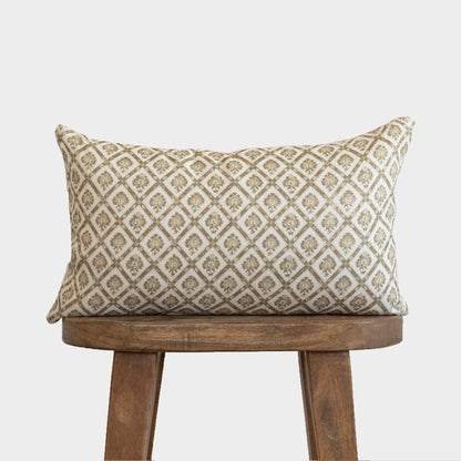 Rectangular lumbar pillow with cream linen and tan geometric diamond pattern, displayed on wooden stool.