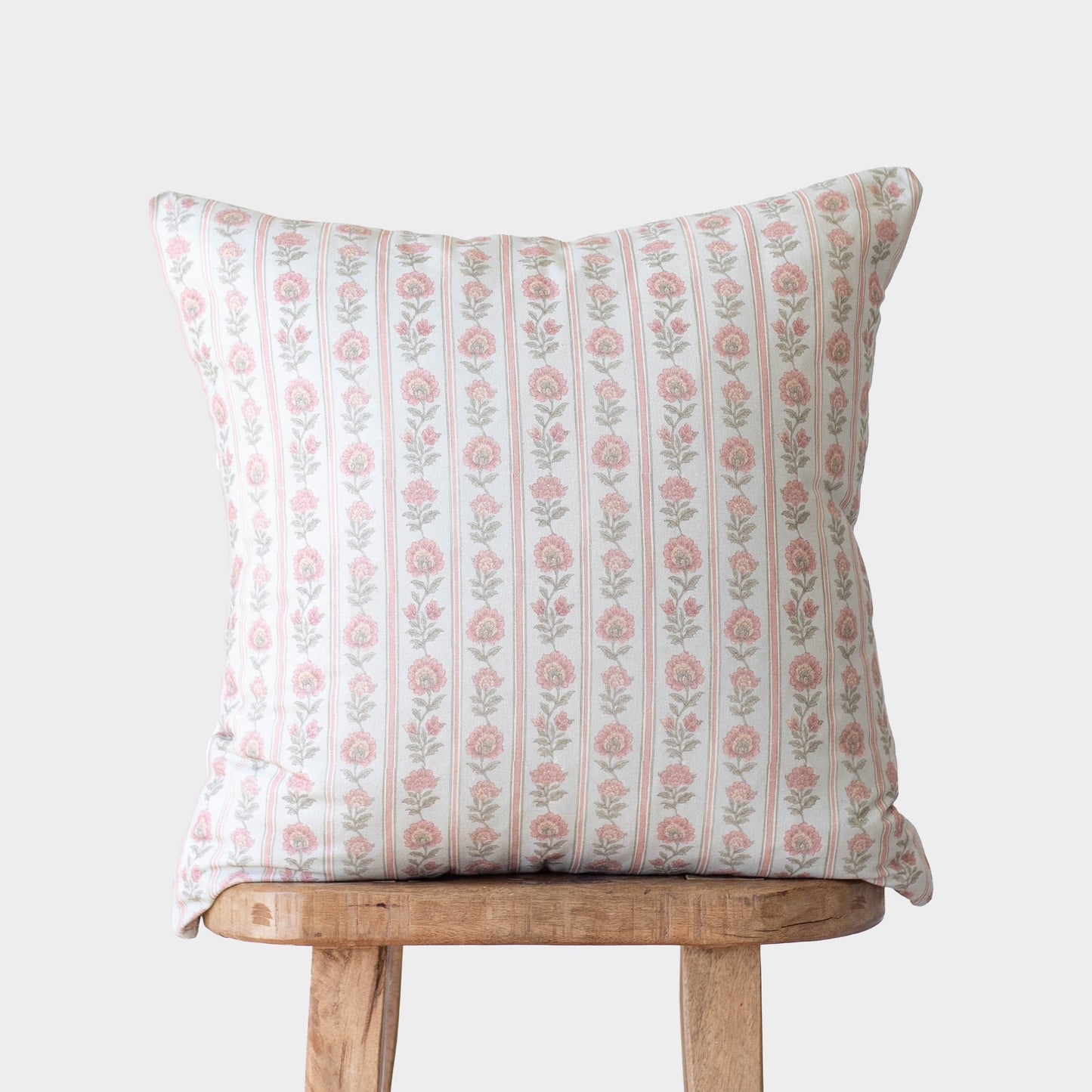 Elise pillow with vertical stripe pattern featuring pink floral motifs on white background.
